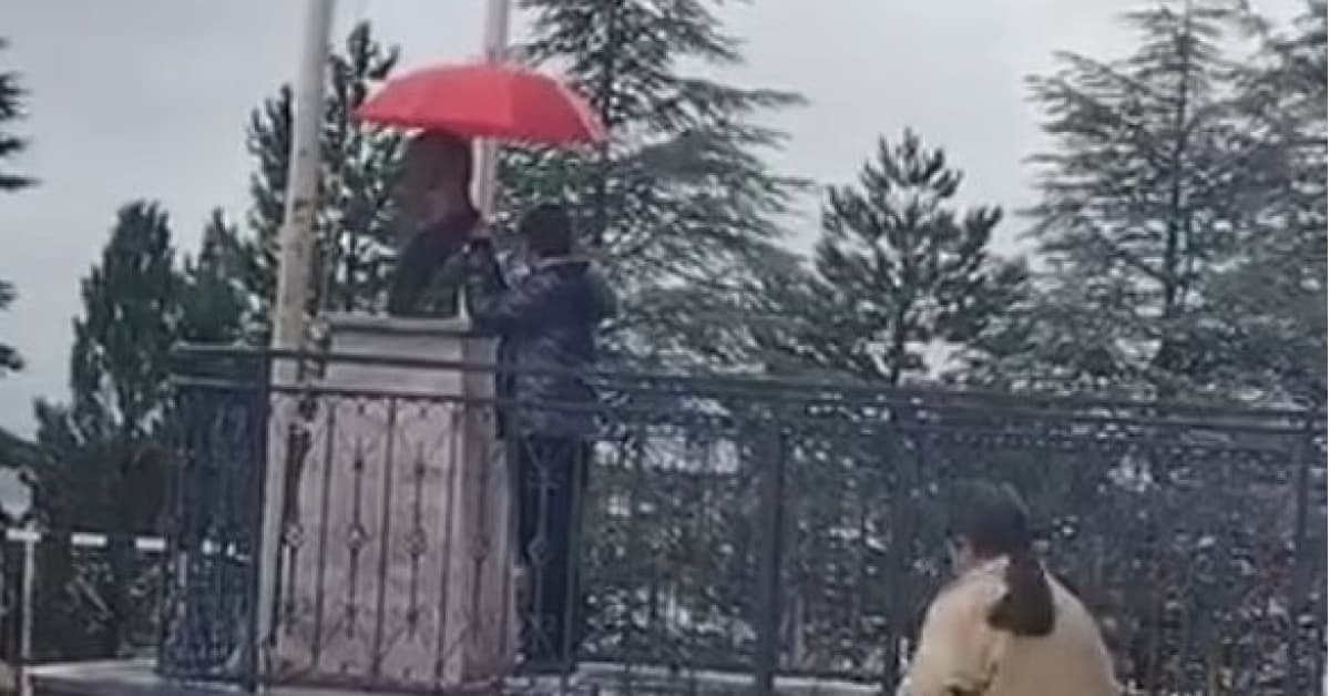 Atatürk büstünü şemsiyeyle korudu